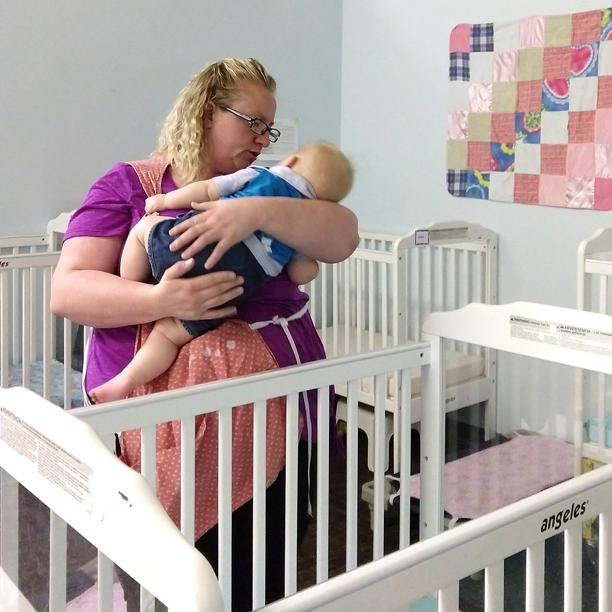 early childhood teacher puts infant down for nap