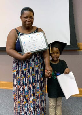 A family proudly displays their LENA Start graduation certificate. 