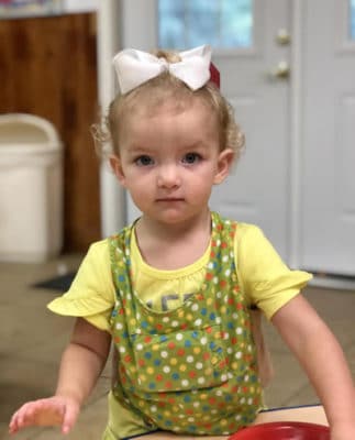 A child with a bow smiles in a Sequatchie Valley classroom.