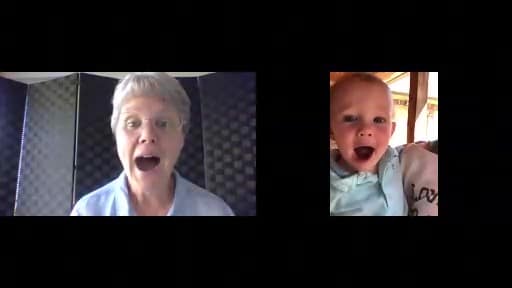 A screenshot of a speech therapist and a baby having a coaching session via video. 