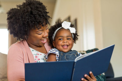 Mom Reading Book to her Daughter