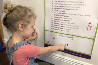 Preschooler putting a sticker on a poster