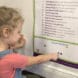 Preschooler putting a sticker on a poster