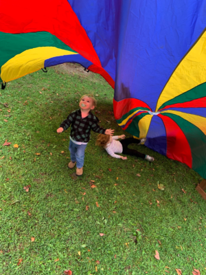 Young children playing with a parachute