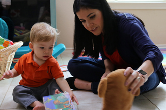 woman reading books and playing with young boy