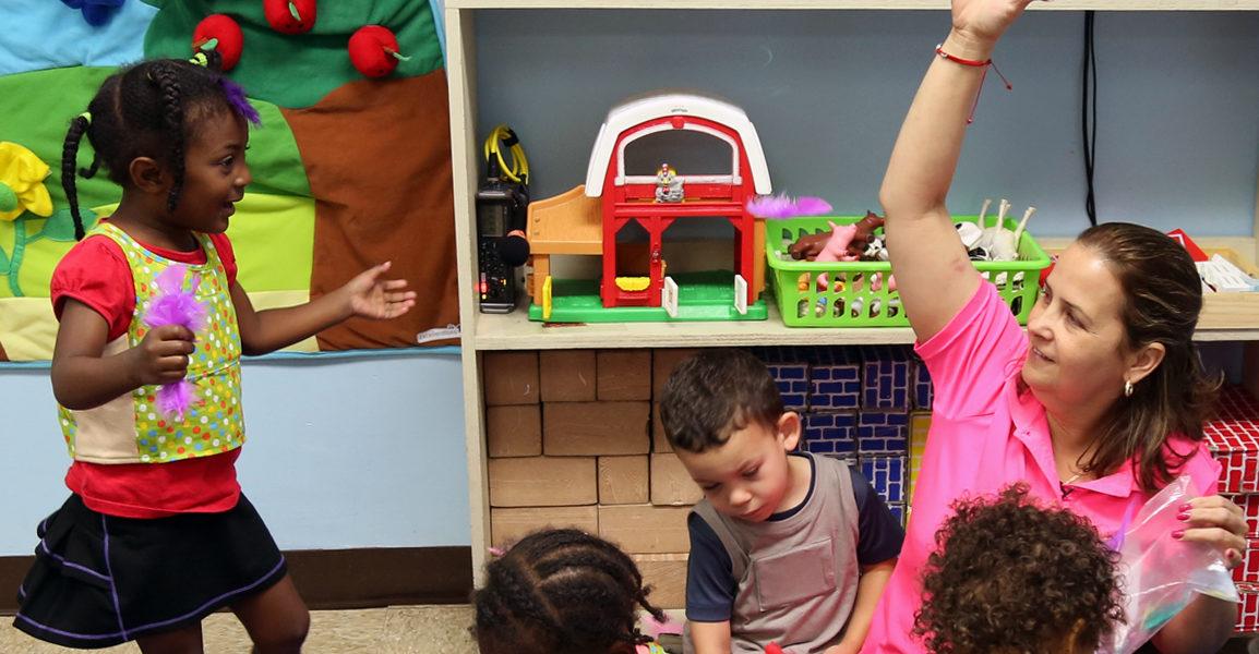 child care teacher smiling with children