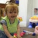 children smiling in toddler classroom wearing LENA vests