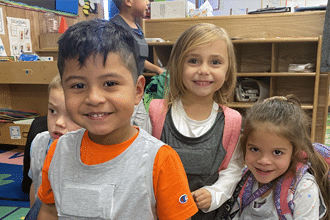 children in preschool room wearing LENA devices