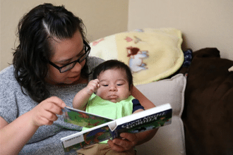 mom and baby reading book together