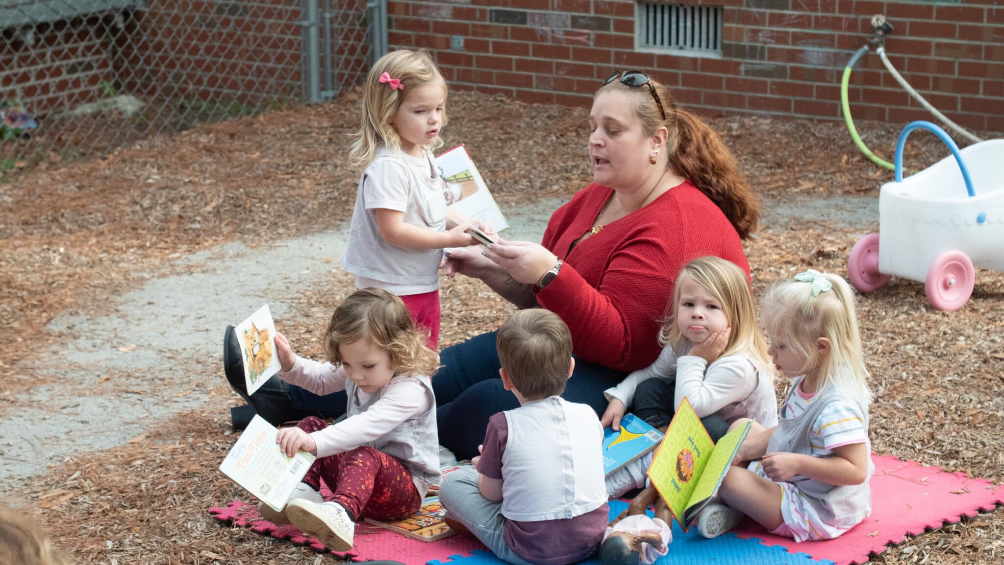 Teacher sitting with students and reading to them.