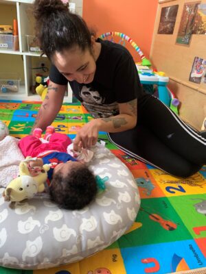 infant playing with her mom in a classroom
