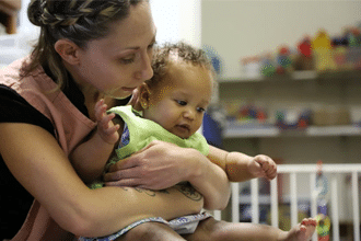 educator holding infant