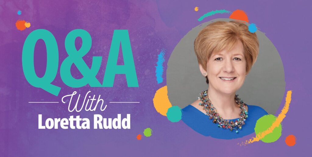 A Q&A promotional graphic features a smiling woman with short light brown hair and a blue top, wearing a colorful necklace, next to the text “Q&A With Loretta Rudd” on a purple background with colorful paint splashes.