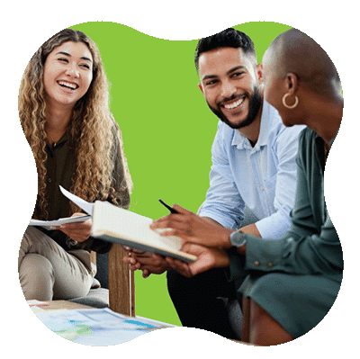Three people sit together, smiling and talking while looking at a notebook. One person holds a pen, and papers are on the table. The background is a solid, bright green shape.