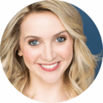 A smiling woman with long blonde hair, blue eyes, and light skin, wearing natural makeup and pearl earrings, against a dark blue background.