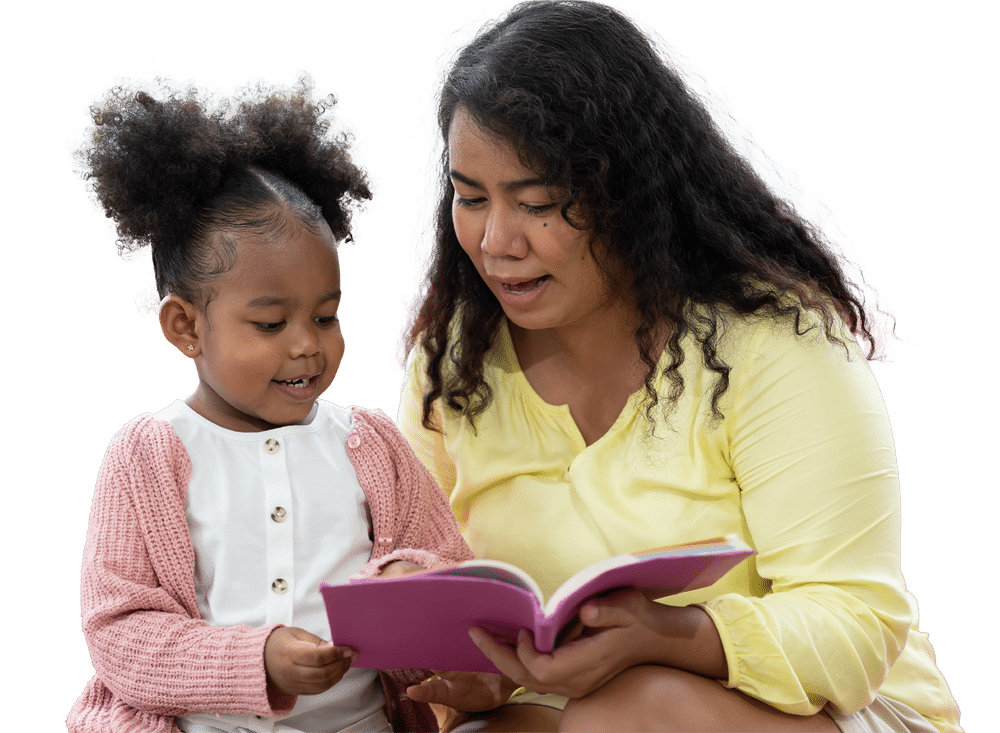 A woman and a young girl smile as they read a pink book together. The woman wears a yellow top and the girl wears a pink sweater and white shirt. Both are seated against a plain white background.