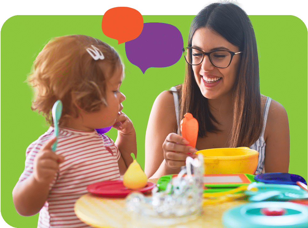 A young woman wearing glasses smiles while sitting at a table with a toddler holding a spoon. Colorful dishes and toy food are on the table, with speech bubble graphics in the background.