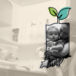 A woman holds a young child in a kitchen, both framed by an illustrated outline of Indiana with a sprouting plant on top. The background is faded, drawing focus to the pair inside the outline.